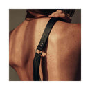 Bijoux Indiscrets Maze Tassel Flogger detail on a model's shoulder, showcasing the sleek black faux leather and tassels.