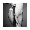 Bijoux Indiscrets Maze Tassel Flogger held by a model, showcasing sleek black faux leather tassels and a stylish design.