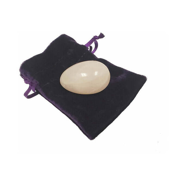 Crystal Egg Kegel Massager Rose Quartz resting on a purple velvet pouch, showcasing its smooth surface.
