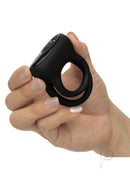 Pleasure Kits Power Play Collection Vibrator Kit Black dual enhancer ring held in hand, showcasing its sleek design.