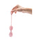 Hand holding the Le Wand Crystal Yoni Eggs Rose Quartz, a luxurious pelvic floor training tool.