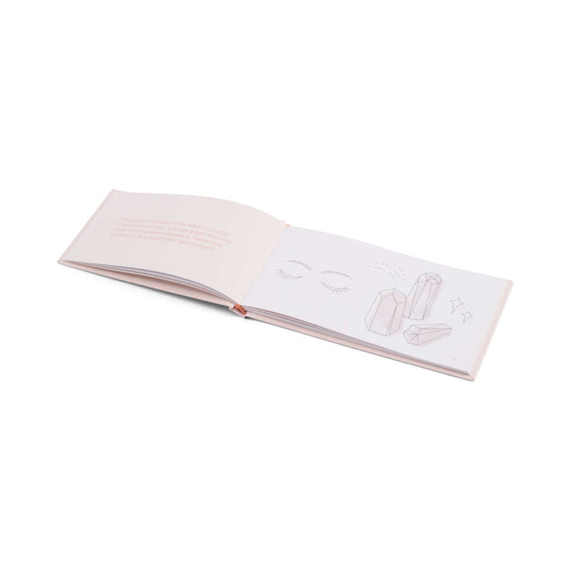 Open book with illustrations of crystals and eyes on the pages, showcasing crystal-related content.