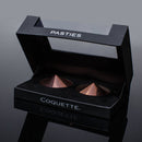 Coquette Pleasure Collection Pasties elegant packaging showcasing round metal design for intimate wear.