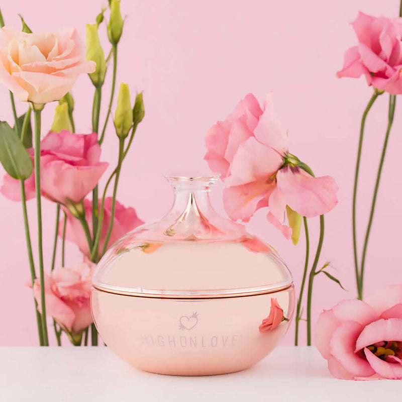 HighOnLove Canna Body Butter surrounded by pink roses on pink background, showcasing a luxurious skincare experience.