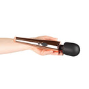 Hand holding the Rosy Gold Nouveau Wand Massager with a sleek design and flexible silicone head.