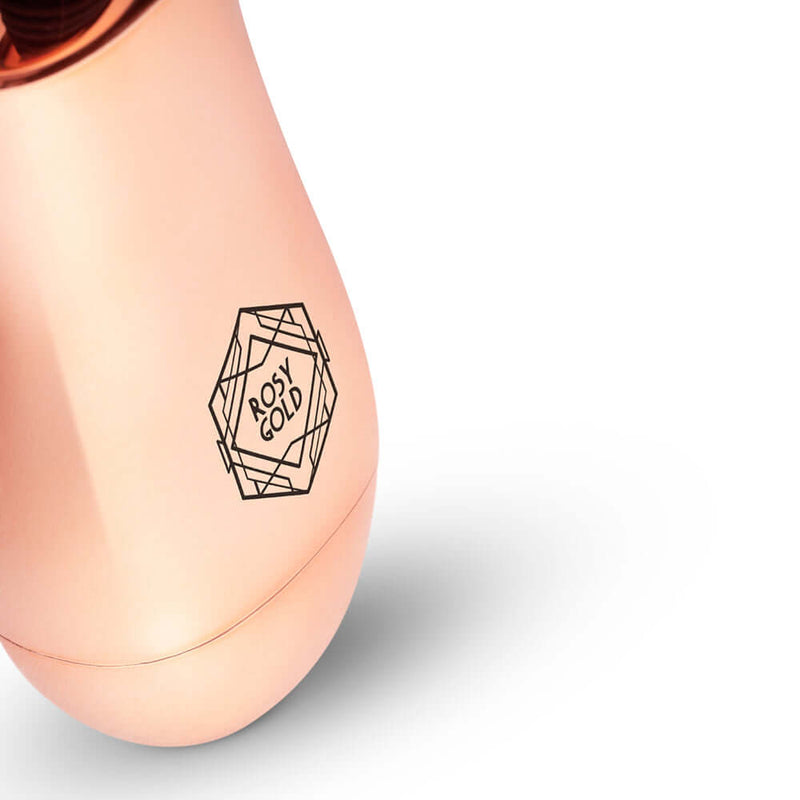 Close-up view of the Rosy Gold Nouveau Mini Massager showcasing its elegant design and logo.
