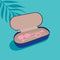 Biird Yonii 2 Piece Rose Quartz Eggs Set inside a zippered case with one egg visible, on a blue background.