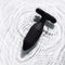 Je Joue Onyx Vibrating Butt Plug Black displayed on a smooth surface with gentle water ripples.