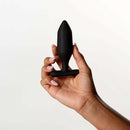Je Joue Onyx Vibrating Butt Plug Black held in hand against a light background, showcasing its sleek design.