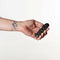 Person holding the Je Joue Onyx Vibrating Butt Plug Black remote control in a hand.