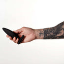 Hand holding Je Joue Egon Vibrating Butt Plug Black showcasing its sleek design and soft material.