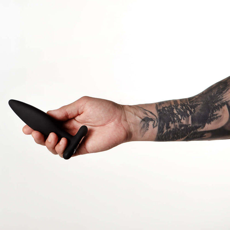 Hand holding Je Joue Egon Vibrating Butt Plug Black showcasing its sleek design and soft material.