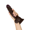 Shaft Model A 10.5 Inch Silicone Dildo With Balls Mahogany held in a hand, showcasing its realistic design.