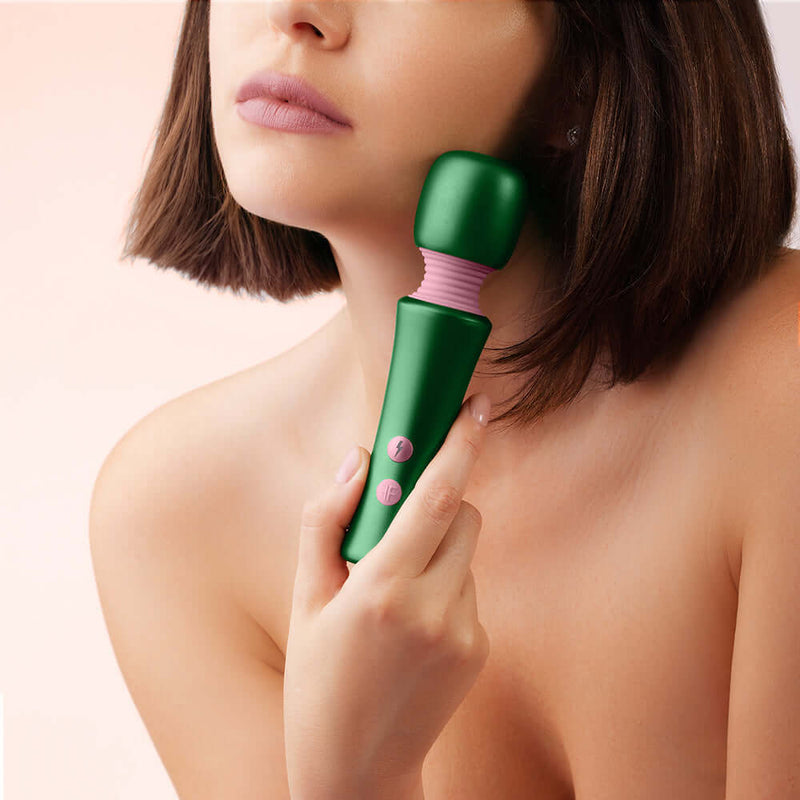 Woman holding FemmeFunn Bougie Wand Massager Green, showcasing its elegant design and functionality.