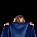 Liberator Fascinator Mini Waterproof Throw Blanket Blue being held by a woman, showcasing its luxurious color and texture.