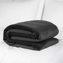 Liberator Fascinator Waterproof Throw Travel Blanket Black folded on a bed.