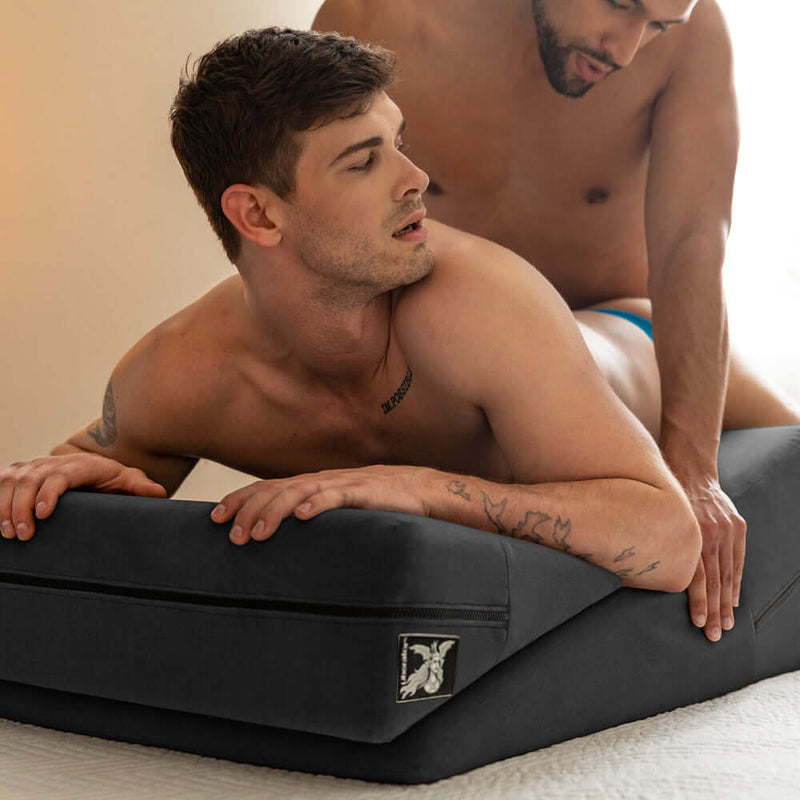 Liberator Wedge and Ramp Sex Positioning Pillow Combo Black in use by two men for enhanced comfort and deepening intimacy.