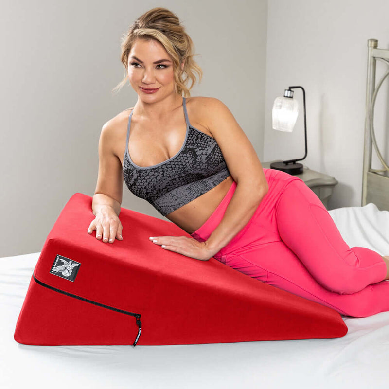 Liberator Ramp Sex Positioning Pillow Original Red on a bed, enhancing intimacy and comfort in bedroom play.