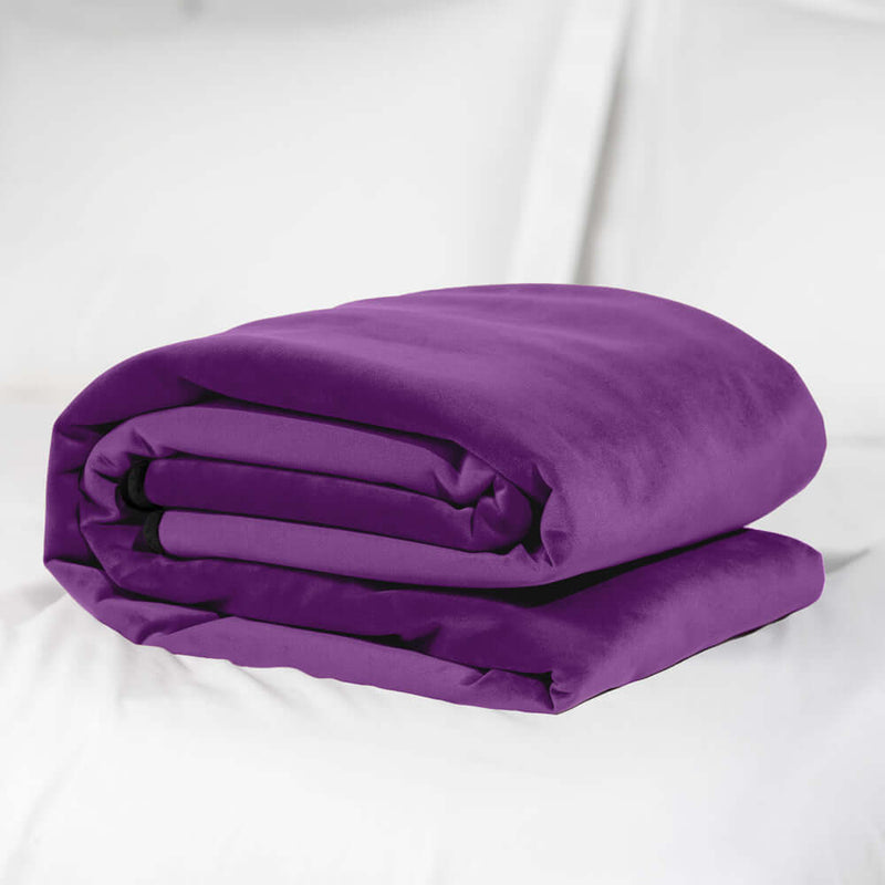 Liberator Fascinator Waterproof Throw Regular Blanket Purple folded on a bed.
