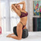 Woman in lingerie enjoying the Liberator Pulse Sex Toy Mount Microfiber Black on a bed, highlighting its ergonomic design.