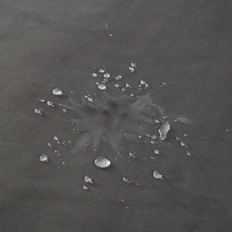 Close-up of water droplets on the Liberator Fascinator Waterproof Throw Travel Blanket Gray, showcasing its waterproof feature.
