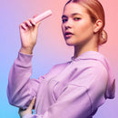 Model showcasing the VUSH Gloss Pocket Rocket Bullet Vibrator in a stylish pink setting.