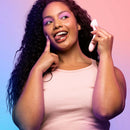 A woman playfully holding the VUSH Shine G-Spot Vibrator, highlighting its stylish design and personal use.