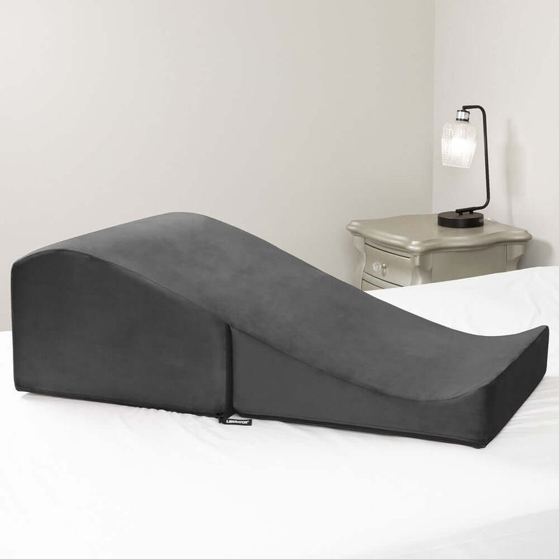 Liberator Flip Ramp Sex Positioning Pillow Black on a bed, designed for heightened intimacy and exploration.