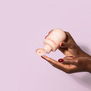 Playground Date Night Water-based Personal Lubricant held in a hand with a gentle pour, showcasing its playful essence.