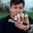 Eye of Love Bloom Attract Her Pheromone Parfum Earths Desire 0.34 Oz held by a person outdoors