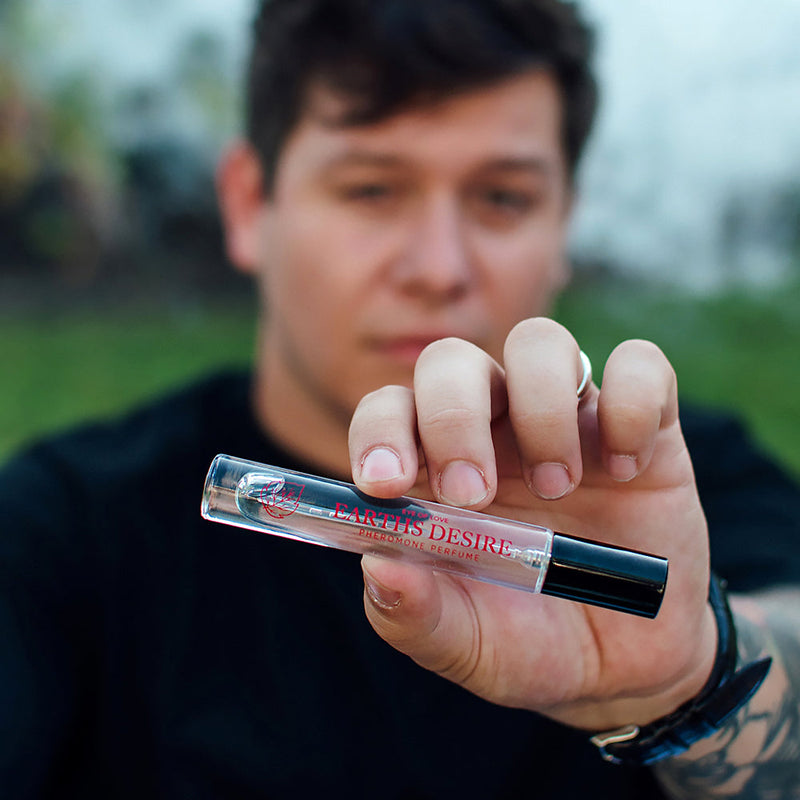 Eye of Love Bloom Attract Her Pheromone Parfum Earths Desire 0.34 Oz held by a person outdoors