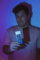 Eye Of Love Bloom Attract Her Pheromone Parfum Blue Ember displayed by a man in a colorful background.