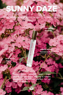 Eye Of Love Bloom Attract Him Pheromone Parfum Sunny Daze bottle with pink flowers background
