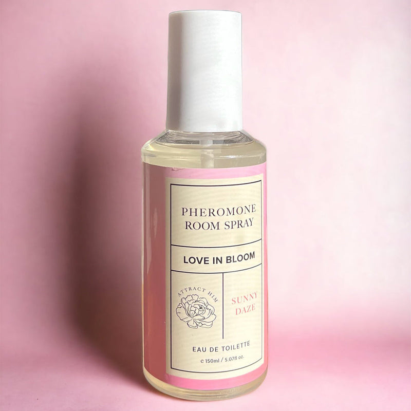 Eye of Love Bloom Attract Him Pheromone Room Spray Sunny Daze 5 Oz in a stylish bottle against a pink background.