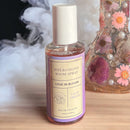 Eye of Love Bloom Attract Him Pheromone Room Spray Lilac Dream 5 Oz in a stylish bottle surrounded by flowers.