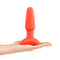 b-Vibe Rimming 2 Rotating and Vibrating Remote Control Plug Orange held in a hand, showcasing its unique design.