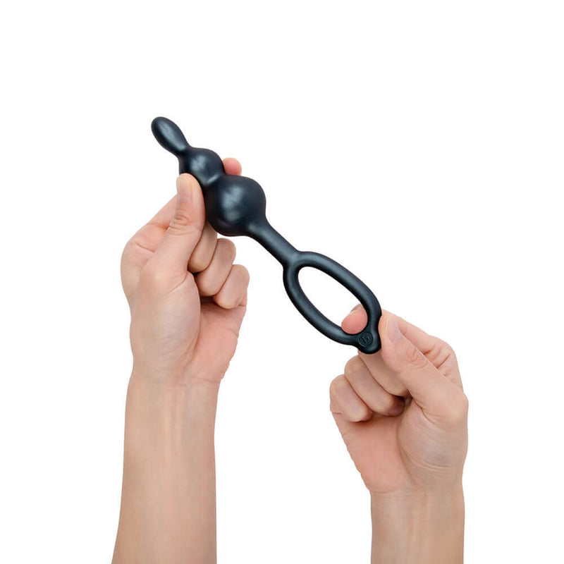 Person holding the b-Vibe Beaded Butties Bundle 3-Piece Anal Plug Set, showcasing its ergonomic design.