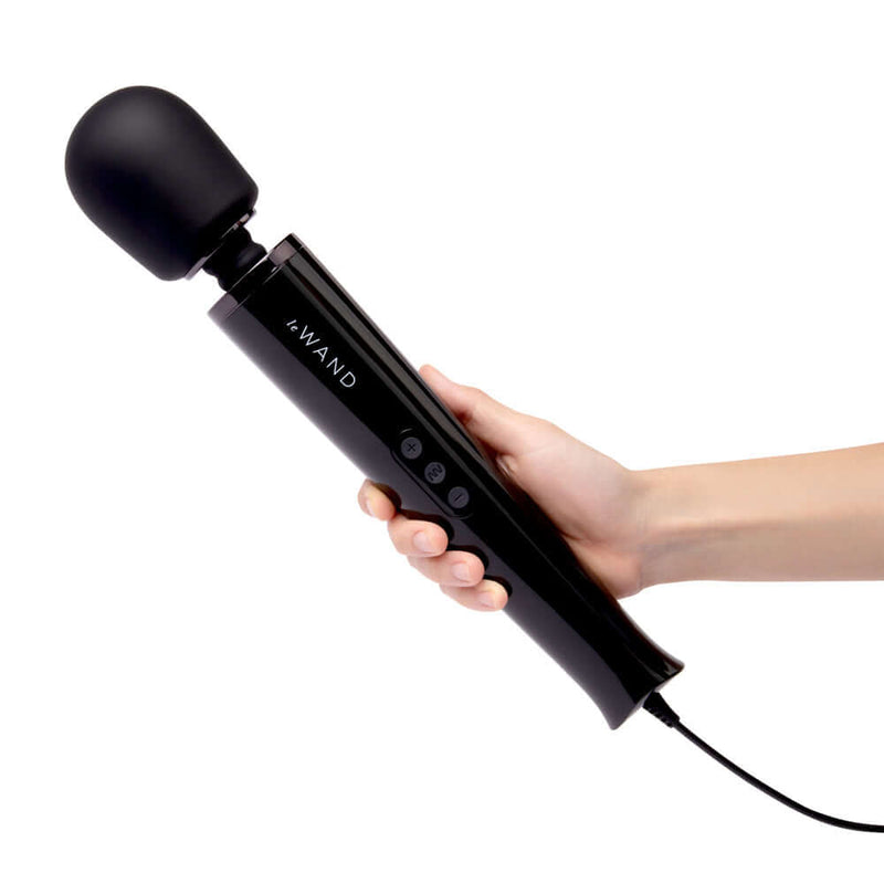 Le Wand Plug-In Vibrating Massager Black held in hand, featuring a sleek design and 8-foot cord for ultimate pleasure.