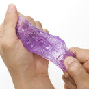 Tenga Uni Amethyst Unisex Finger Sleeve Stroker being squeezed in a hand for optimal pleasure.
