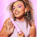 VUSH Siren Twist Vibrator held by a smiling person with curly hair against a pink background.