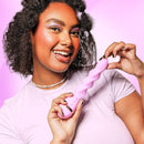 VUSH Siren Twist Vibrator held by a smiling woman with curly hair, showcasing its unique design and vibrant color.