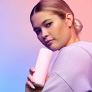 Model holding VUSH Glow Rabbit Vibrator against a colorful pastel background.