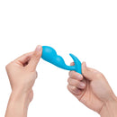 b-Vibe Vibrating P-Spot Snug Plug Small with Remote Control held in hand, showcasing its sleek design and ergonomic shape.