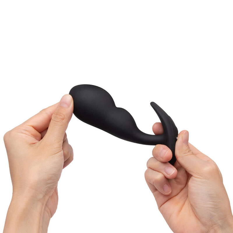 b-Vibe Vibrating P-Spot Snug Plug Large with Remote Control held in hands for targeted pleasure.
