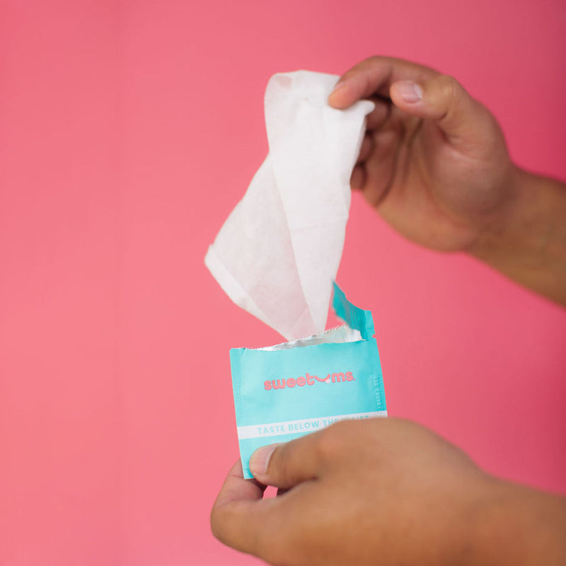 Sweetums Intimate Wipes Cinnamon Bun Flavor 10 Pack being opened, showcasing the wipes for intimate care.