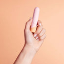 VUSH Peachy Collection Bullet Vibrator held in hand against a peach background.