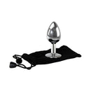 Adam & Eve Clear Gem Anal Plug Medium placed on a black pouch, showcasing its polished aluminum design.