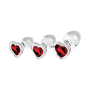 Adam & Eve Red Heart Gem Glass Plug Set featuring three graduated glass plugs with red heart-shaped gem bases.