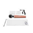 Le Wand Die Cast Rechargeable Massager Rose Gold with accessories and user guides on a white surface.