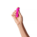 Dame Zig Lipstick Vibrator Pink held in hand, showcasing its compact design and vibrant color for on-the-go pleasure.